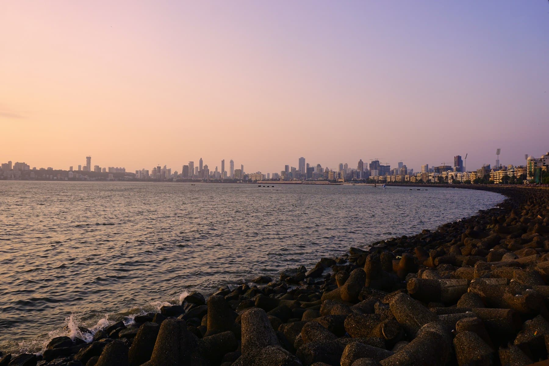 Mumbai's skyline across the sea at golden hour